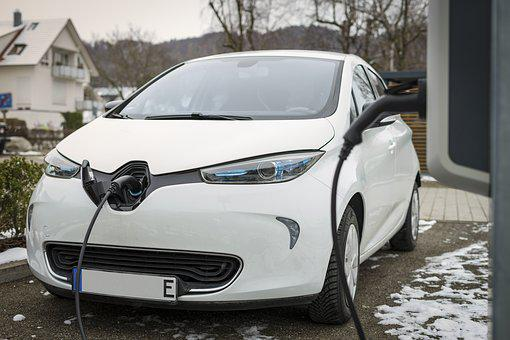 véhicule blanc électrique en train d'être rechargé